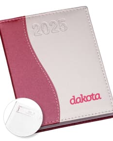 Agenda Diária 2025 aberta sobre uma mesa de escritório, ao lado de um notebook, papéis em branco, envelope, livro, mensagens, páginas vazias, pastas de escritório, documentos e um bloco de notas. A imagem representa um ambiente corporativo e de organização.