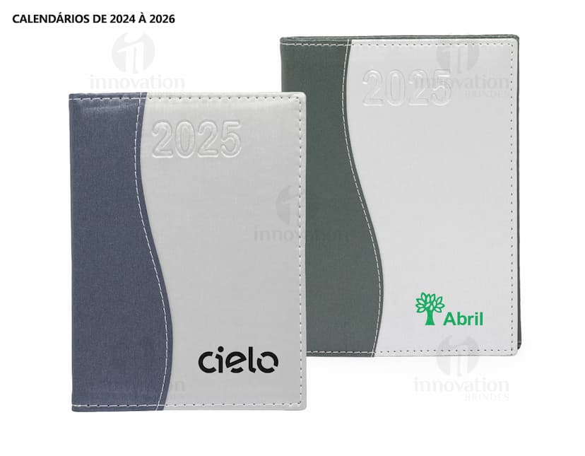 Agenda Diária 2025 aberta sobre uma mesa de escritório, ao lado de um notebook, papéis em branco, envelope, livro, mensagens, páginas vazias, pastas de escritório, documentos e um bloco de notas. A imagem representa um ambiente corporativo e de organização.