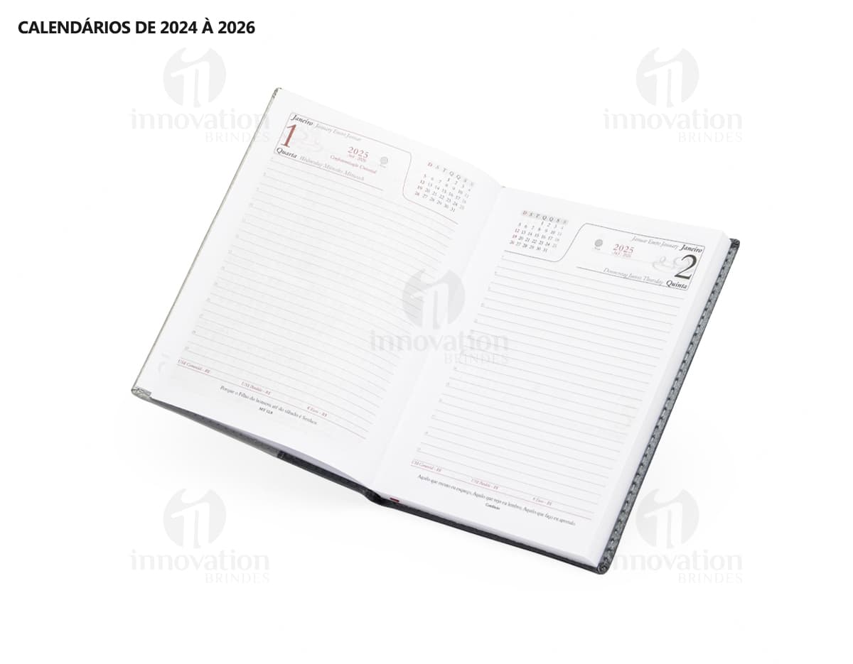 Agenda Diária 2025 aberta sobre uma mesa de escritório, ao lado de um notebook, papéis em branco, envelope, livro, mensagens, páginas vazias, pastas de escritório, documentos e um bloco de notas. A imagem representa um ambiente corporativo e de organização.