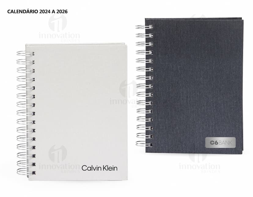 Foto de uma agenda diária para o ano de 2025, com capa marrom e uma espiral para folhear as páginas. Na imagem, é possível ver espaços em branco para escrever notas e lembretes, com um lápis e régua ao lado. A agenda está aberta em uma página em branco, pronta para ser preenchida com informações e compromissos.