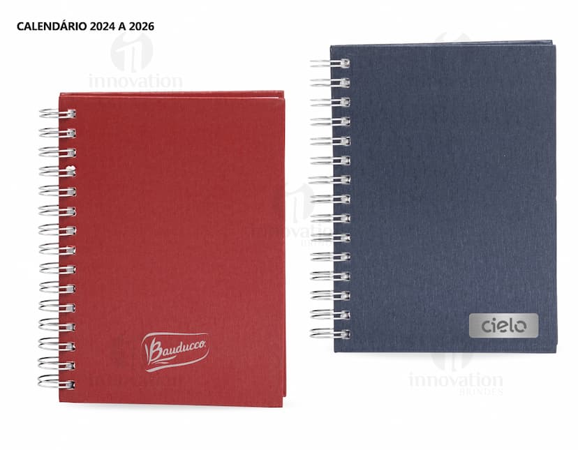 Foto de uma agenda diária para o ano de 2025, com capa marrom e uma espiral para folhear as páginas. Na imagem, é possível ver espaços em branco para escrever notas e lembretes, com um lápis e régua ao lado. A agenda está aberta em uma página em branco, pronta para ser preenchida com informações e compromissos.