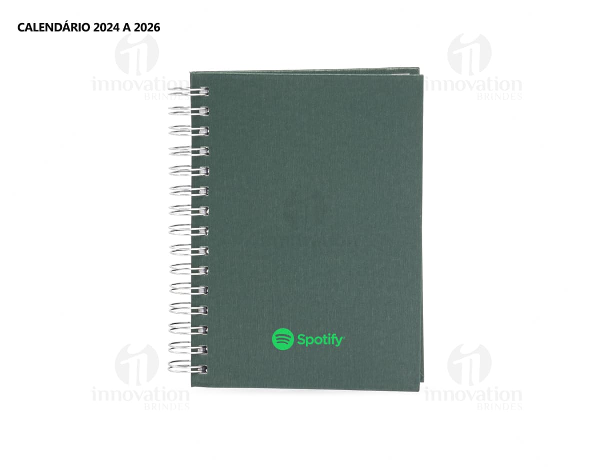 Foto de uma agenda diária para o ano de 2025, com capa marrom e uma espiral para folhear as páginas. Na imagem, é possível ver espaços em branco para escrever notas e lembretes, com um lápis e régua ao lado. A agenda está aberta em uma página em branco, pronta para ser preenchida com informações e compromissos.