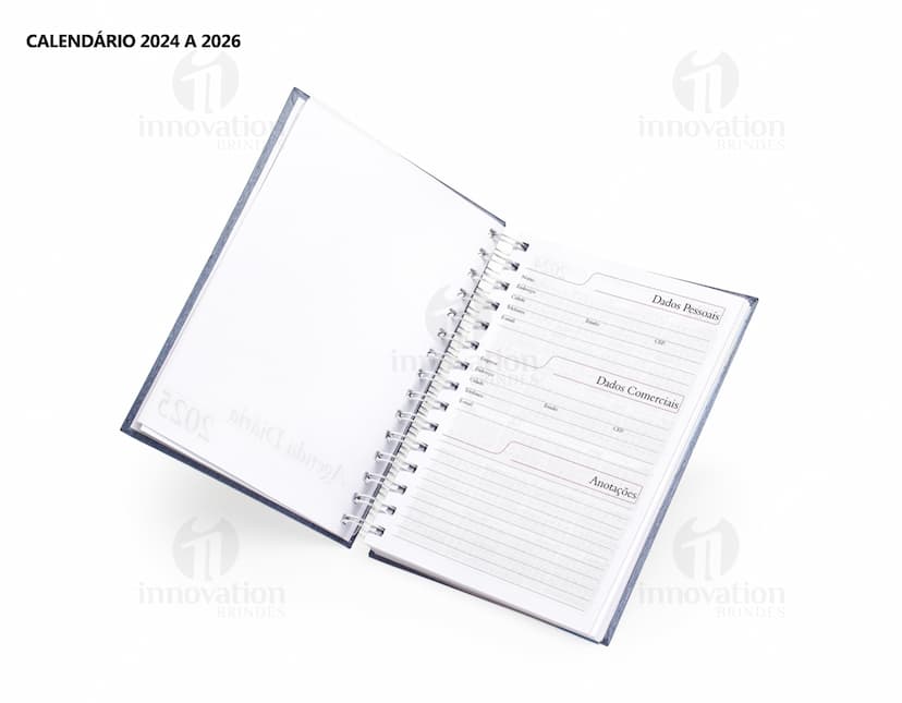 Foto de uma agenda diária para o ano de 2025, com capa marrom e uma espiral para folhear as páginas. Na imagem, é possível ver espaços em branco para escrever notas e lembretes, com um lápis e régua ao lado. A agenda está aberta em uma página em branco, pronta para ser preenchida com informações e compromissos.