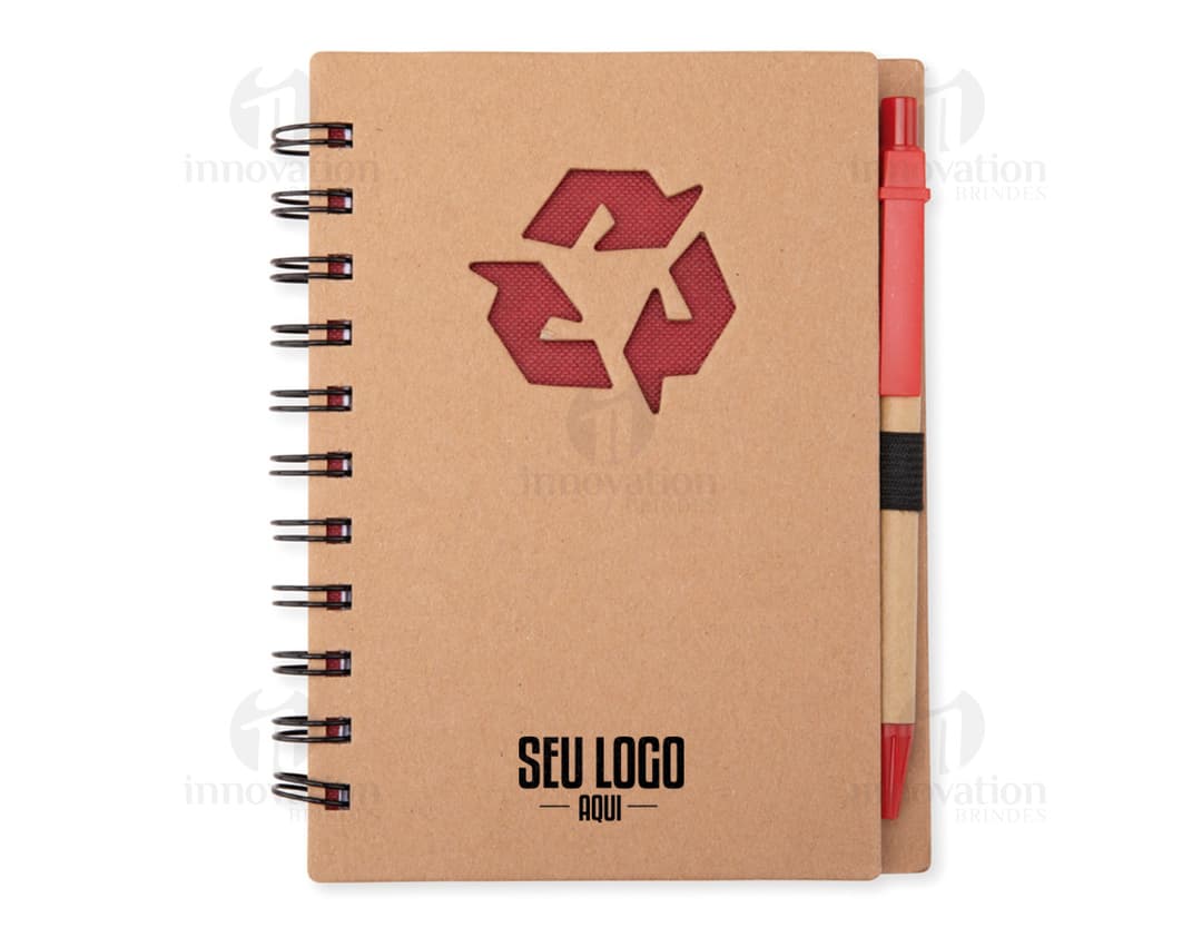 Caderno ecológico com caneta sobre uma mesa de escritório, ao lado de um papel em branco, uma mensagem escrita, um objeto de