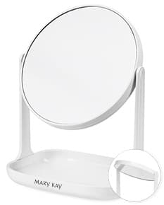 Espelho de mesa plástico em um ambiente de escritório moderno, ao lado de um mouse de computador e um teclado. A superfície reflete o reflexo de um golfista em ação, com destaque para o design elegante e a textura brilhante do objeto. O fundo é neutro e vazio, transmitindo uma sensação de limpeza e organização. A imagem sugere um ambiente profissional e tecnológico.
