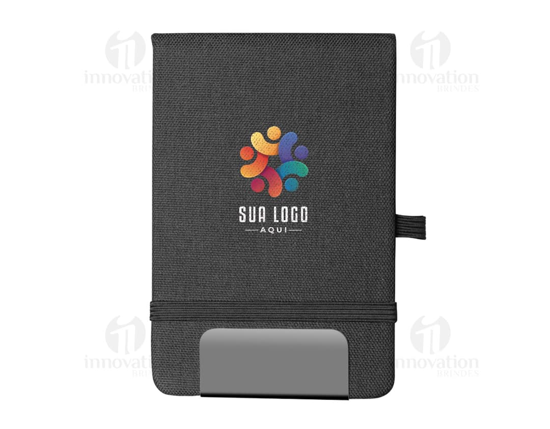 Mini Cuaderno marrón de cuero, abierto, con página en blanco. Al lado, un pen drive, un llavero, un diario negro y un