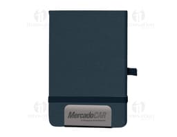 Mini Cuaderno marrón de cuero, abierto, con página en blanco. Al lado, un pen drive, un llavero, un diario negro y un