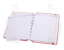 Caderno de Disco em branco com capa listrada amarela e textura de couro aberto em cima de uma pilha de papéis e notas, com um