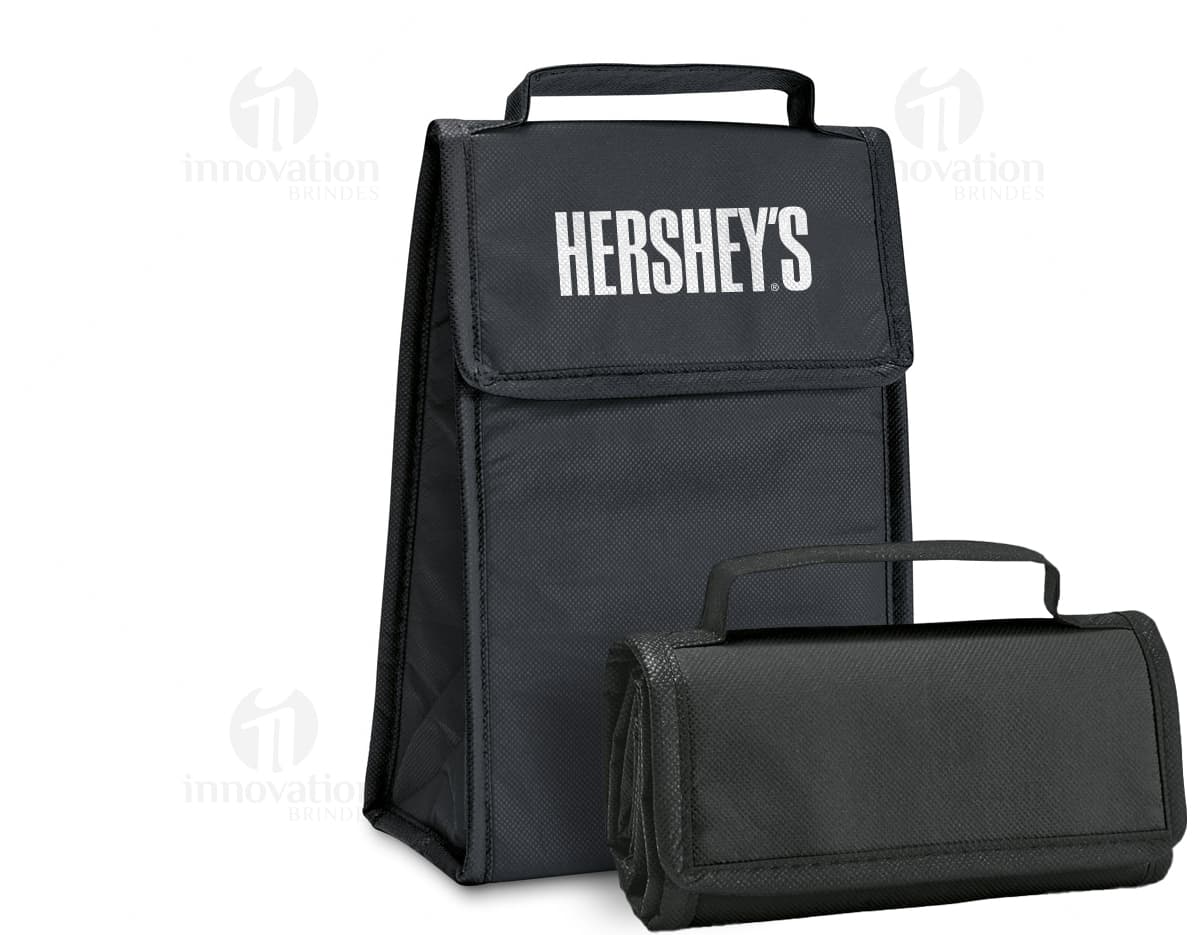 Bolsa térmica dobrável em formato 3D, vazia e aberta, com design moderno e clean. Está sobre uma mesa ao lado de um computador, um notebook e um dispenser de sabonete. A imagem contém elementos como embalagem de plástico, papel em branco, ícones de tecnologia e etiquetas de informação.