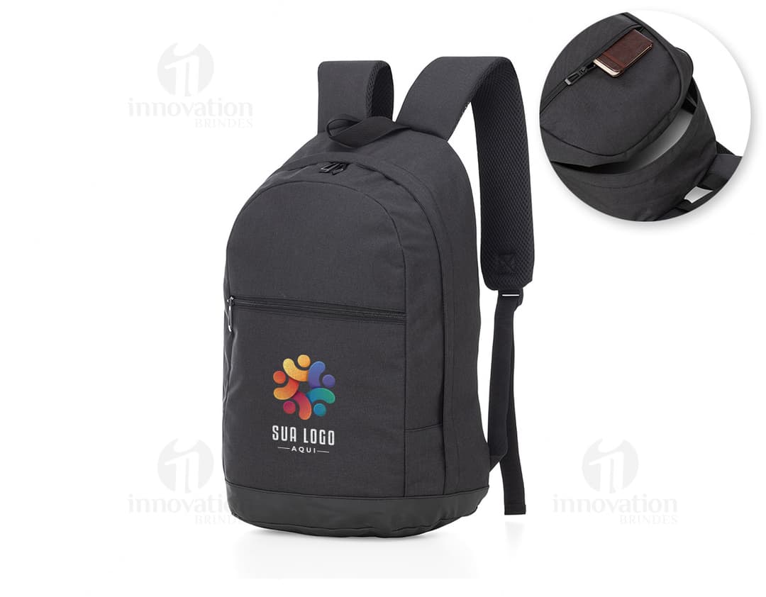 Homem de terno preto segurando uma mochila de nylon preta com alça de couro, adequada para notebook de até 16,5 polegadas.