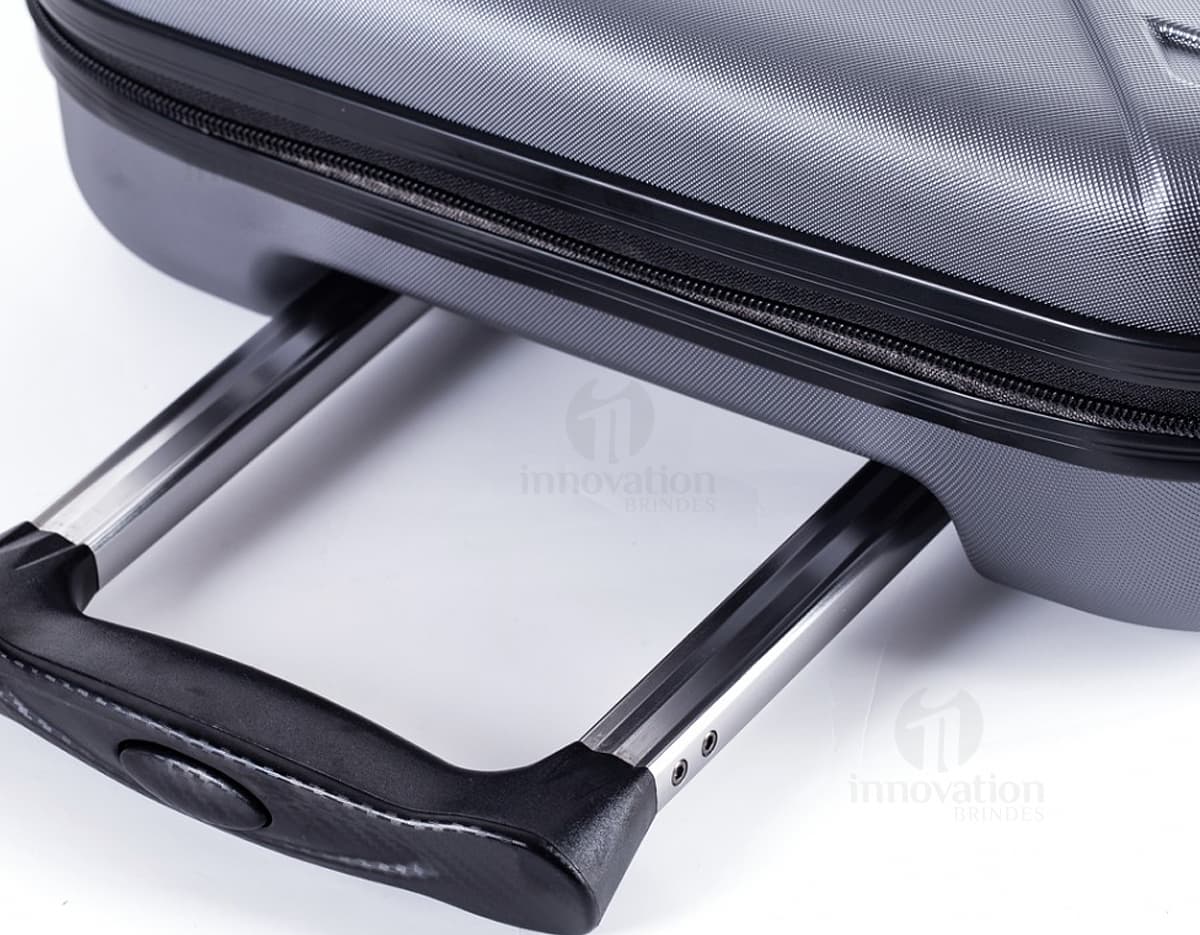 Mala de viagem pequena de tecido lateral em ABS, preta e moderna. Contém equipamentos eletrônicos e de áudio no interior, com design vintage e fecho de metal. Ideal para viagens de negócios ou lazer.