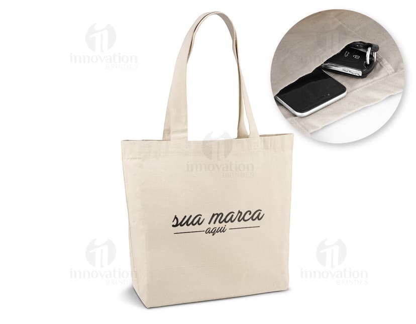 Sacola de algodão canvas 280g com bolso, ideal para compras e transporte de mercadorias. Feita de material resistente, possui um design moderno e elegante. Perfeita para uso comercial ou pessoal, garantindo segurança e proteção para seus pertences. Cor marrom, com alças e fecho de metal, proporcionando praticidade e estilo.