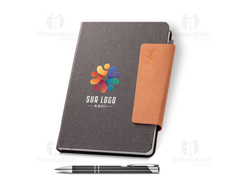 Agenda A5 com fecho magnético, em couro marrom, aberta mostrando página em branco, caneta sobre a folha. Objeto de escritório, business, tecnologia, informação e educação.