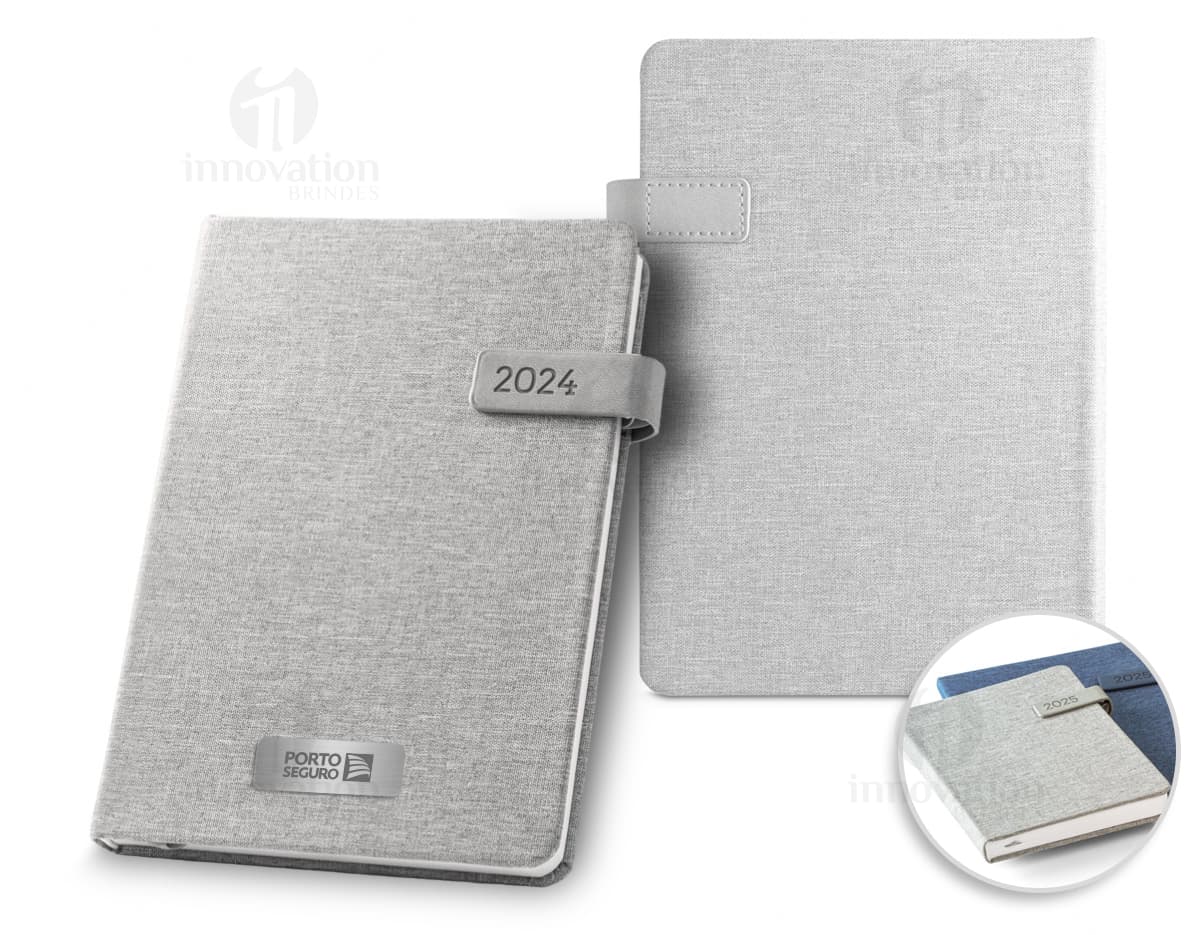 Agenda A5 preta com fecho magnético e suporte, em estilo retro. Possui teclado, botões, páginas em branco, ícones e símbolos financeiros, representando organização e sucesso nos negócios. Feita de couro sintético rPET, com design elegante e funcional para armazenar informações e garantir segurança.