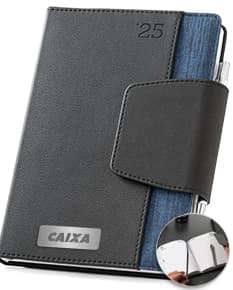 Agenda A5 Bi-Material c/ Fecho Magnético, que pode ser vista na imagem, possui características como couro preto, organiza documentos, dinheiro e chaves, é um item de escritório com fecho magnético, perfeito para armazenar informações e dados importantes de forma segura e prática.