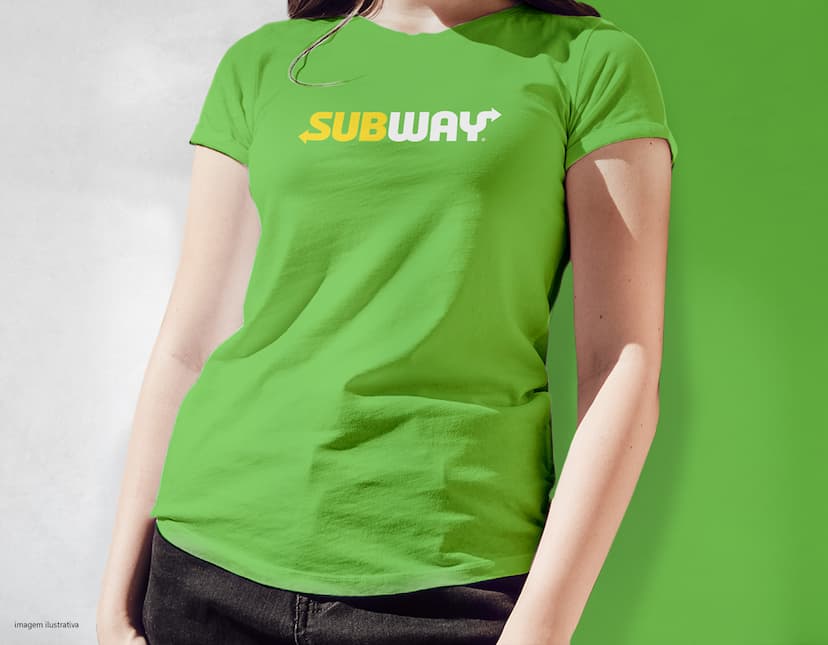 Homem jovem e atraente, sorrindo, usando uma camiseta preta. Ele está em pé, confiante e feliz, em um estúdio. O modelo possui um estilo moderno e casual, representando um estilo de vida saudável e esportivo. O jovem tem cabelos escuros e olhos azuis, transmitindo jovialidade e felicidade.