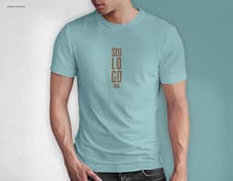 Homem jovem e atraente sorrindo, posando em um estúdio com uma t-shirt preta de algodão tradicional de 165g/m². Ele está a
