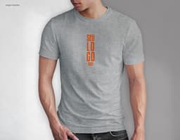 Homem jovem e atraente sorrindo, posando em um estúdio com uma t-shirt preta de algodão tradicional de 165g/m². Ele está a