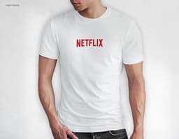 Homem jovem e atraente sorrindo, posando em um estúdio com uma t-shirt preta de algodão tradicional de 165g/m². Ele está a