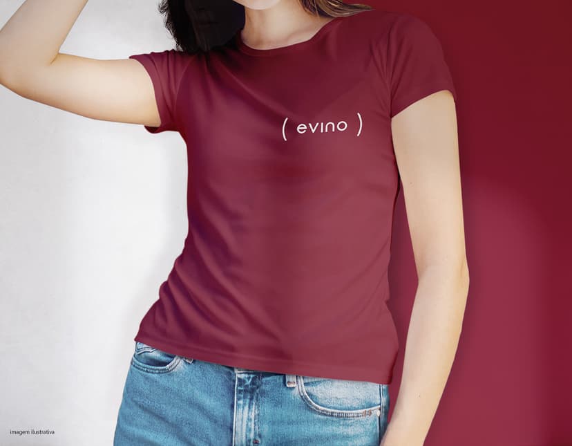 Camiseta feminina de corte cinturado em cor azul, usada por uma modelo sorridente e atraente. Ela está posando de forma casual e elegante, com cabelo escuro e jeans. A roupa é moderna e estilosa, perfeita para mulheres jovens e modernas.