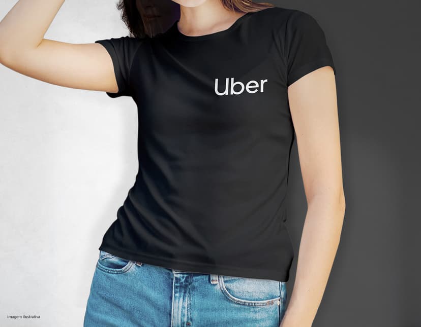 Camiseta feminina de corte cinturado em cor azul, usada por uma modelo sorridente e atraente. Ela está posando de forma casual e elegante, com cabelo escuro e jeans. A roupa é moderna e estilosa, perfeita para mulheres jovens e modernas.