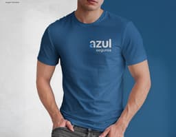 Homem jovem e atraente posando de maneira casual com uma camiseta de algodão tradicional. Ele está sorrindo e tem um sorriso