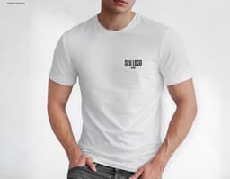 Homem jovem e atraente posando de maneira casual com uma camiseta de algodão tradicional. Ele está sorrindo e tem um sorriso