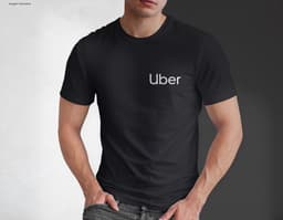 Homem jovem e atraente posando de maneira casual com uma camiseta de algodão tradicional. Ele está sorrindo e tem um sorriso