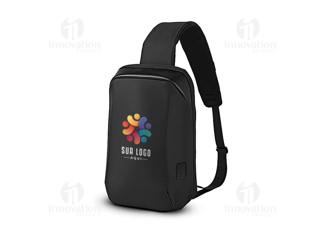 Mochila transversal preta com diversos bolsos e compartimentos, ideal para transportar laptop, dispositivos eletrônicos e materiais de trabalho. Perfeita para quem busca praticidade e organização no dia a dia.