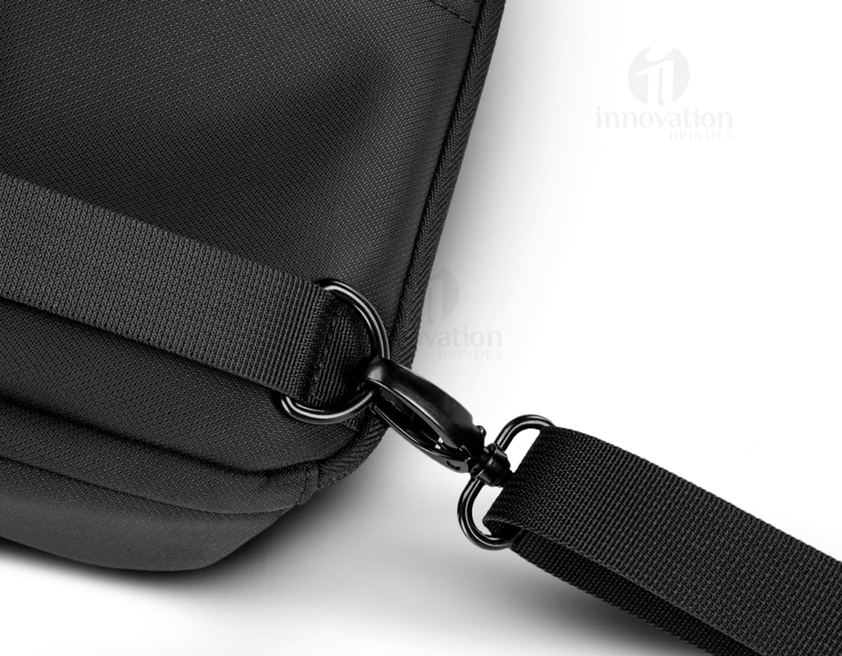 Mochila transversal preta com diversos bolsos e compartimentos, ideal para transportar laptop, dispositivos eletrônicos e materiais de trabalho. Perfeita para quem busca praticidade e organização no dia a dia.