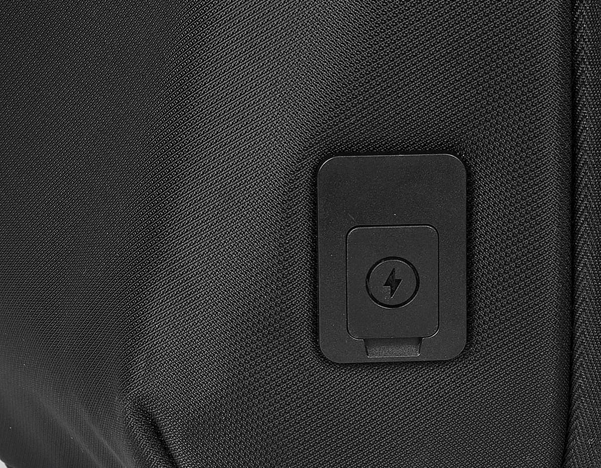 Mochila transversal preta com diversos bolsos e compartimentos, ideal para transportar laptop, dispositivos eletrônicos e materiais de trabalho. Perfeita para quem busca praticidade e organização no dia a dia.