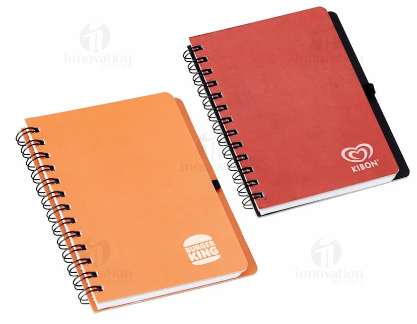 Caderneta Capa Dura Kraft para anotações e organização de documentos, com capa protetora de papelão resistente. Ideal para uso no escritório, estudos, finanças e viagens. Contém páginas em branco para anotações e lembretes, em um design prático e elegante. Cor preta, com espiral de metal, perfeita para guardar memórias e ideias.