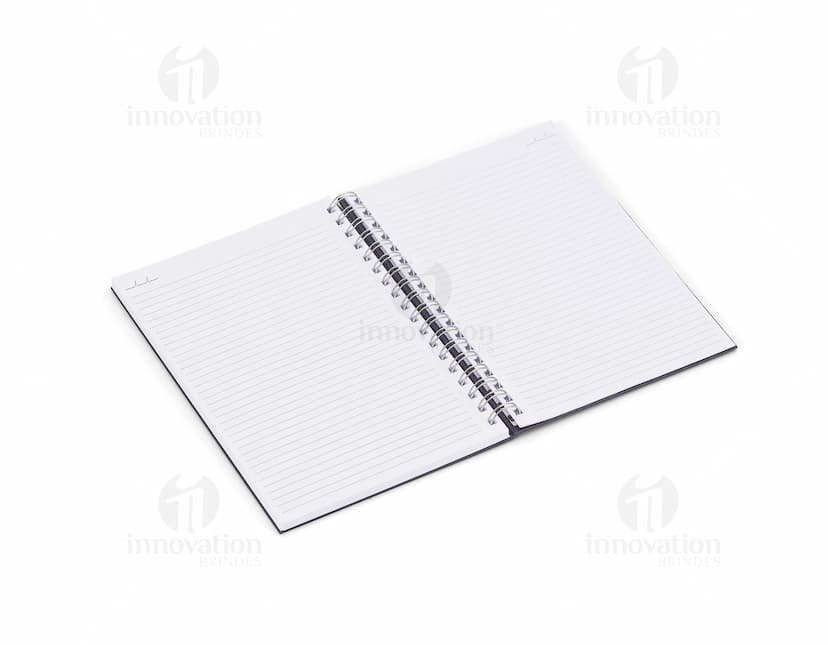 Caderno em branco aberto sobre uma mesa de escritório, com uma caneta ao lado. O caderno possui linhas para escrever e um design simples e moderno. A imagem também mostra um notebook e outros materiais de escrita ao fundo.