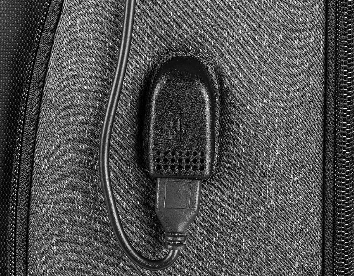 Mochila Premium para notebook com USB, possui fecho de metal, bolso em jeans, detalhes em couro, design vintage e botão de pressionar.