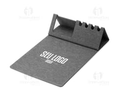 Mouse pad de cuero marrón abierto sobre una mesa de oficina, alrededor hay un portátil negro, un bolso de cuero, llaves, una
