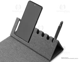 Mouse pad de cuero marrón abierto sobre una mesa de oficina, alrededor hay un portátil negro, un bolso de cuero, llaves, una