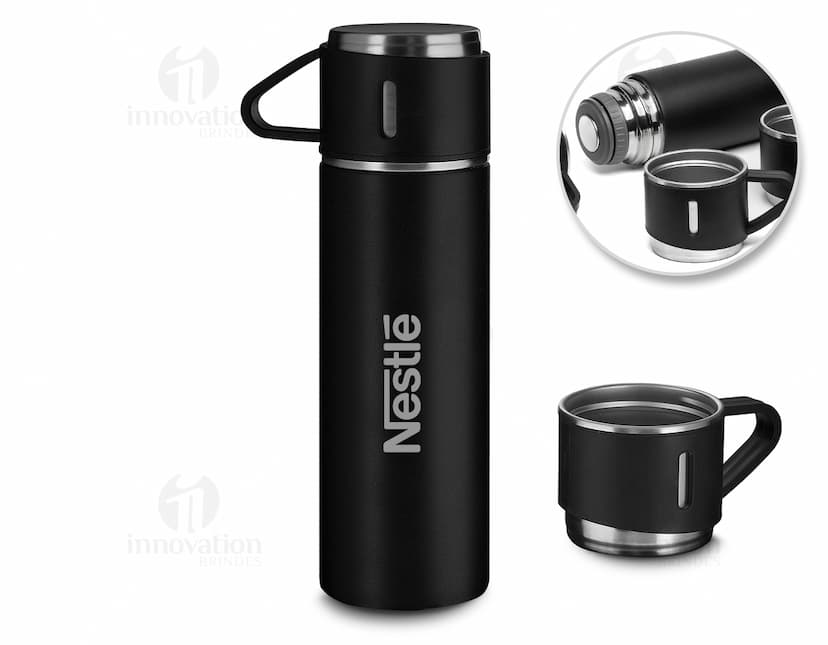 Kit garrafa e copo contendo líquidos e produtos de higiene e cuidados pessoais, como loção, desodorante, perfume, álcool, shampoo, gel e creme. As garrafas são de plástico e metal, com rótulos e tampas brancas. O copo é de vidro transparente. A imagem mostra também outros objetos de banheiro e cuidados pessoais, como sabonete, aerosol e toalhas.