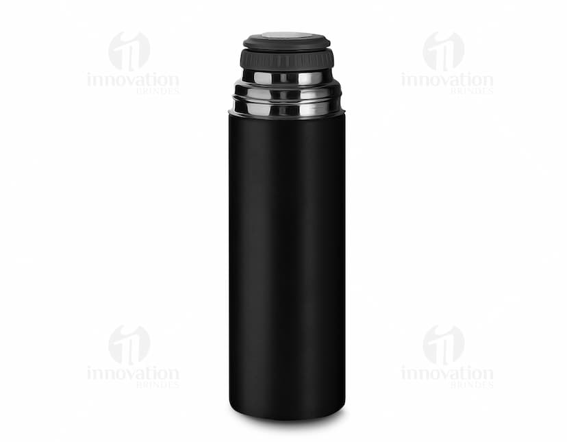Kit garrafa e copo contendo líquidos e produtos de higiene e cuidados pessoais, como loção, desodorante, perfume, álcool, shampoo, gel e creme. As garrafas são de plástico e metal, com rótulos e tampas brancas. O copo é de vidro transparente. A imagem mostra também outros objetos de banheiro e cuidados pessoais, como sabonete, aerosol e toalhas.