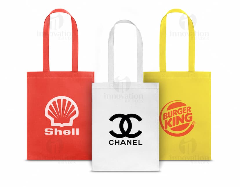 SACOLA 270 x 350 mm amarela com design fashion em uma boutique de shopping, protegida por um cadeado e etiqueta de segurança. O produto está dentro de uma embalagem de metal seguro e protegido.