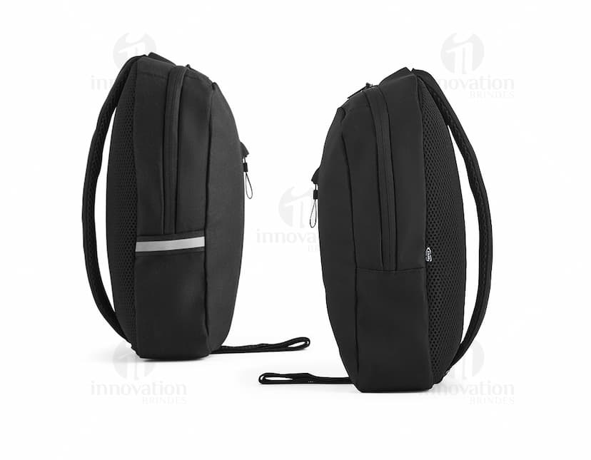 Homem de terno preto segurando uma mochila tiracolo feita de rPET com refletores.