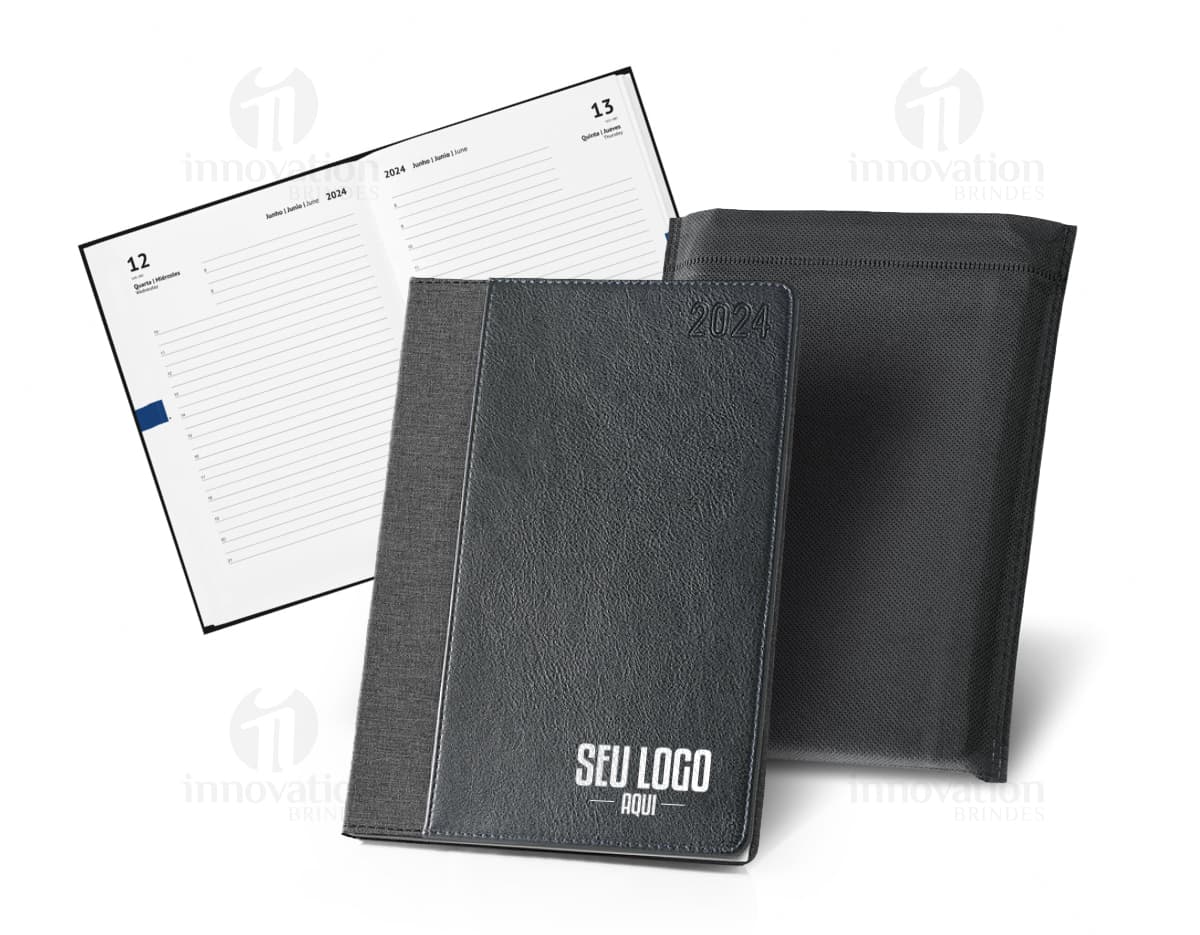Agenda A5 rPET com bolso frontal para escrita e organização de compromissos, com design moderno e clean. Ideal para uso diário no escritório ou em casa, com espaço para notas e lembretes. Possui capa preta e textura vintage, representando um produto prático e funcional para o dia a dia.
