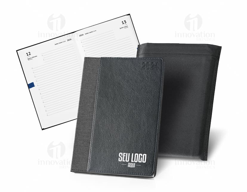 Agenda A5 rPET com bolso frontal para escrita e organização de compromissos, com design moderno e clean. Ideal para uso diário no escritório ou em casa, com espaço para notas e lembretes. Possui capa preta e textura vintage, representando um produto prático e funcional para o dia a dia.