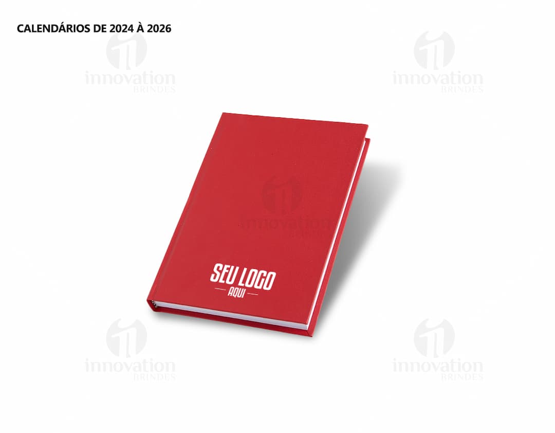 Agenda 2025 Cromato com capa em amarelo, vazio, na mesa de escritório com notebook, papel em branco, livro aberto e envelope.