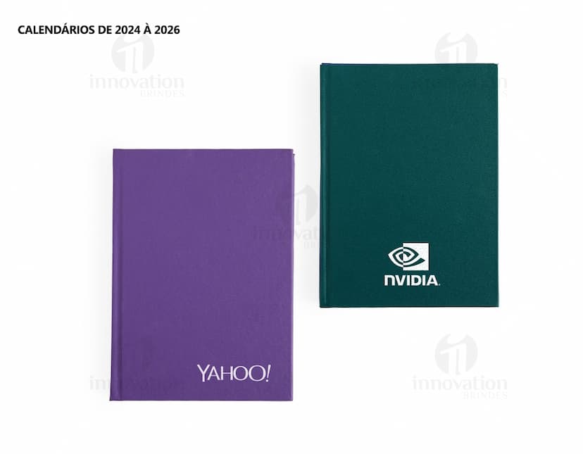 Agenda 2025 Cromato com capa em amarelo, vazio, na mesa de escritório com notebook, papel em branco, livro aberto e envelope.