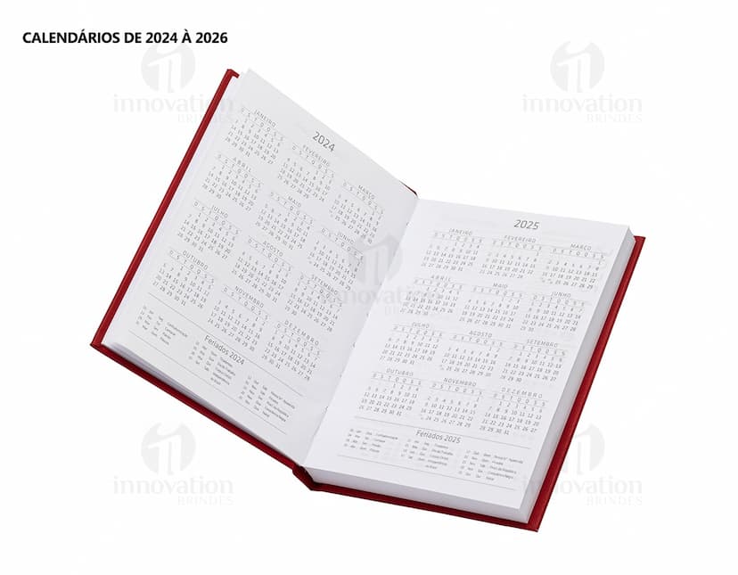 Agenda 2025 Cromato com capa em amarelo, vazio, na mesa de escritório com notebook, papel em branco, livro aberto e envelope.
