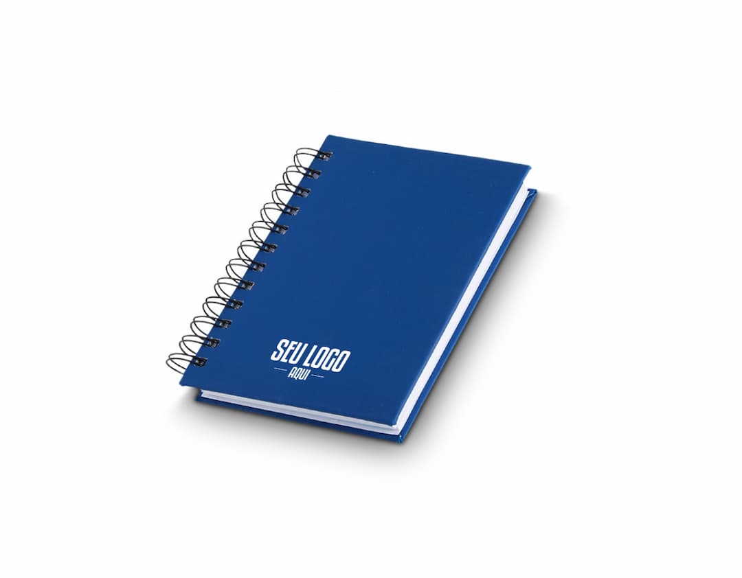 Agenda 2025 Emborrachada em uma mesa de escritório, ao lado de um notebook, dispositivo de internet, roteador, papel em branco, equipamentos de escritório e livros.