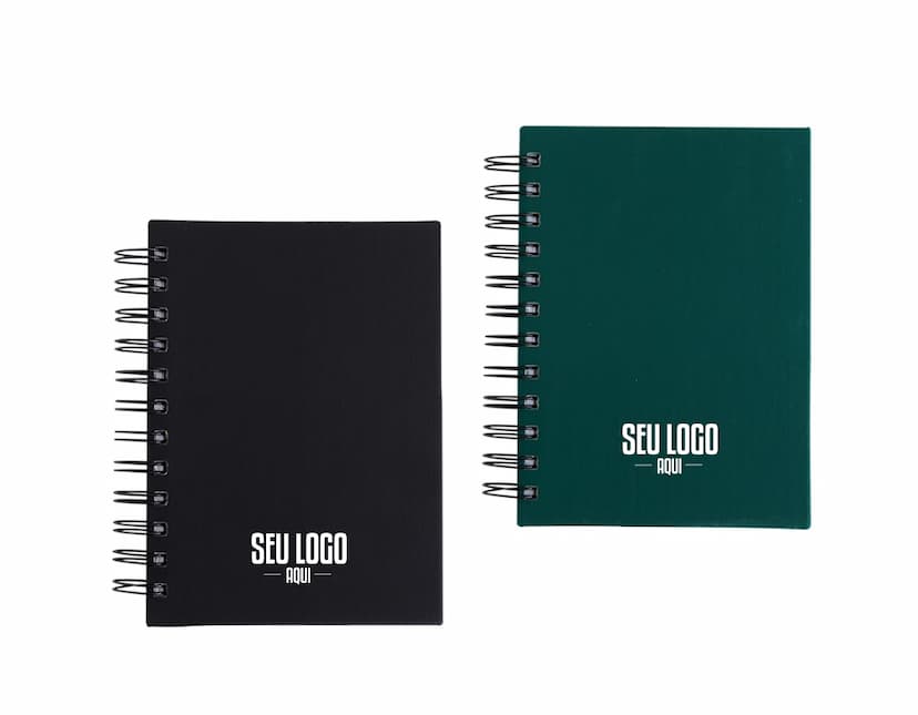 Agenda 2025 Emborrachada em uma mesa de escritório, ao lado de um notebook, dispositivo de internet, roteador, papel em branco, equipamentos de escritório e livros.