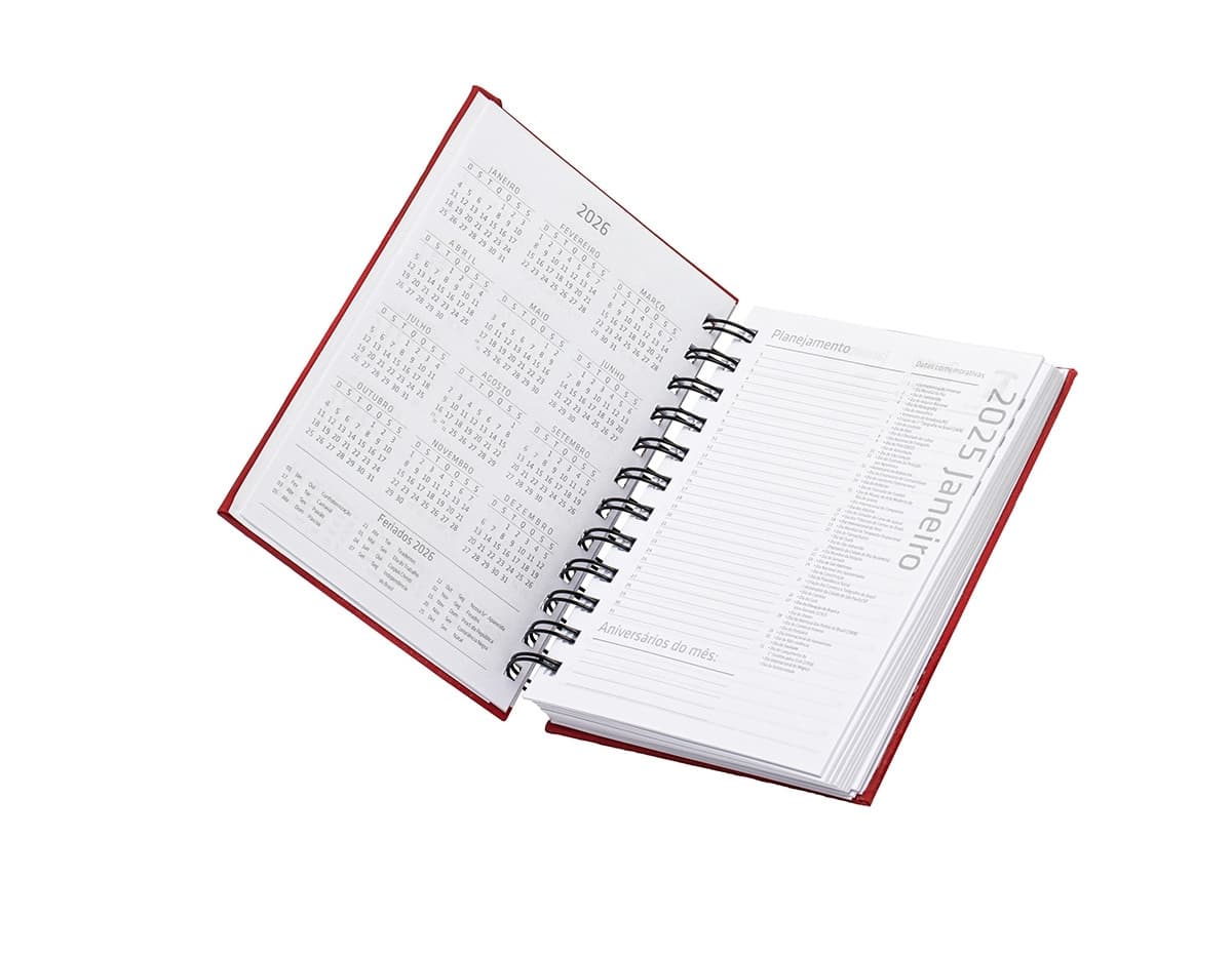Agenda 2025 Emborrachada em uma mesa de escritório, ao lado de um notebook, dispositivo de internet, roteador, papel em branco, equipamentos de escritório e livros.