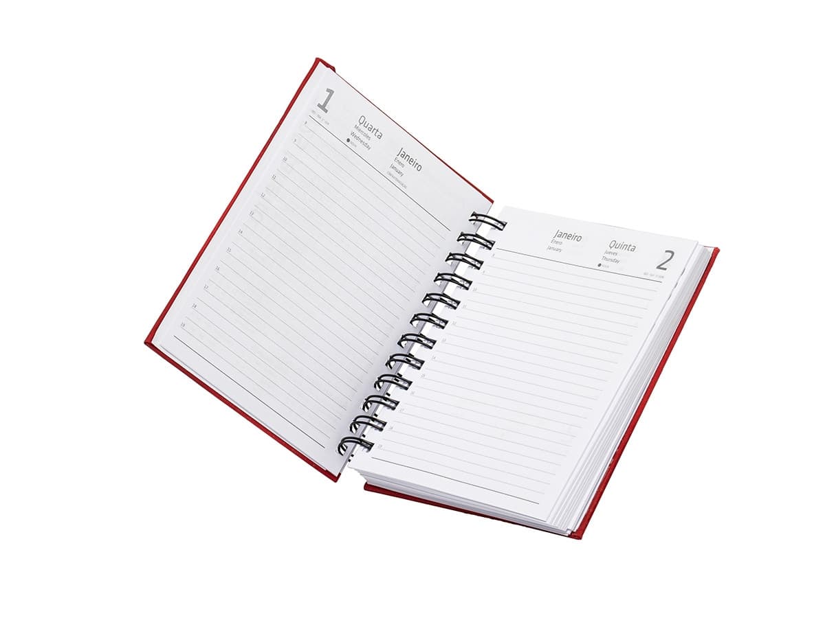 Agenda 2025 Emborrachada em uma mesa de escritório, ao lado de um notebook, dispositivo de internet, roteador, papel em branco, equipamentos de escritório e livros.