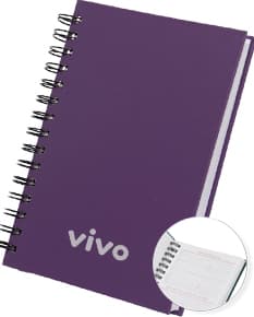 Agenda 2025 Cromato prata com design moderno e espaço para escrever notas, feita de metal resistente. Ao fundo, um campo de golfe e um notebook aberto com driver e roteador.